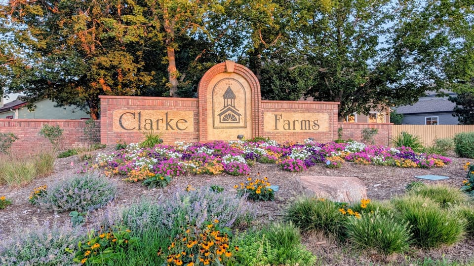 Clarke Farms brick entrance monument on a fall evening