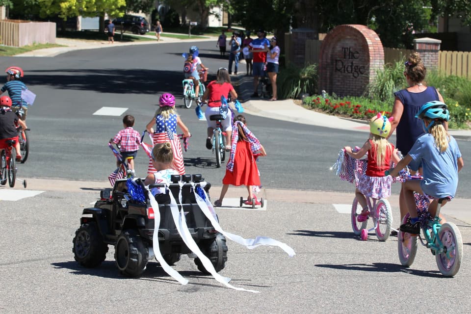 Kids riding decorated bikes and scooters through the neighborhood